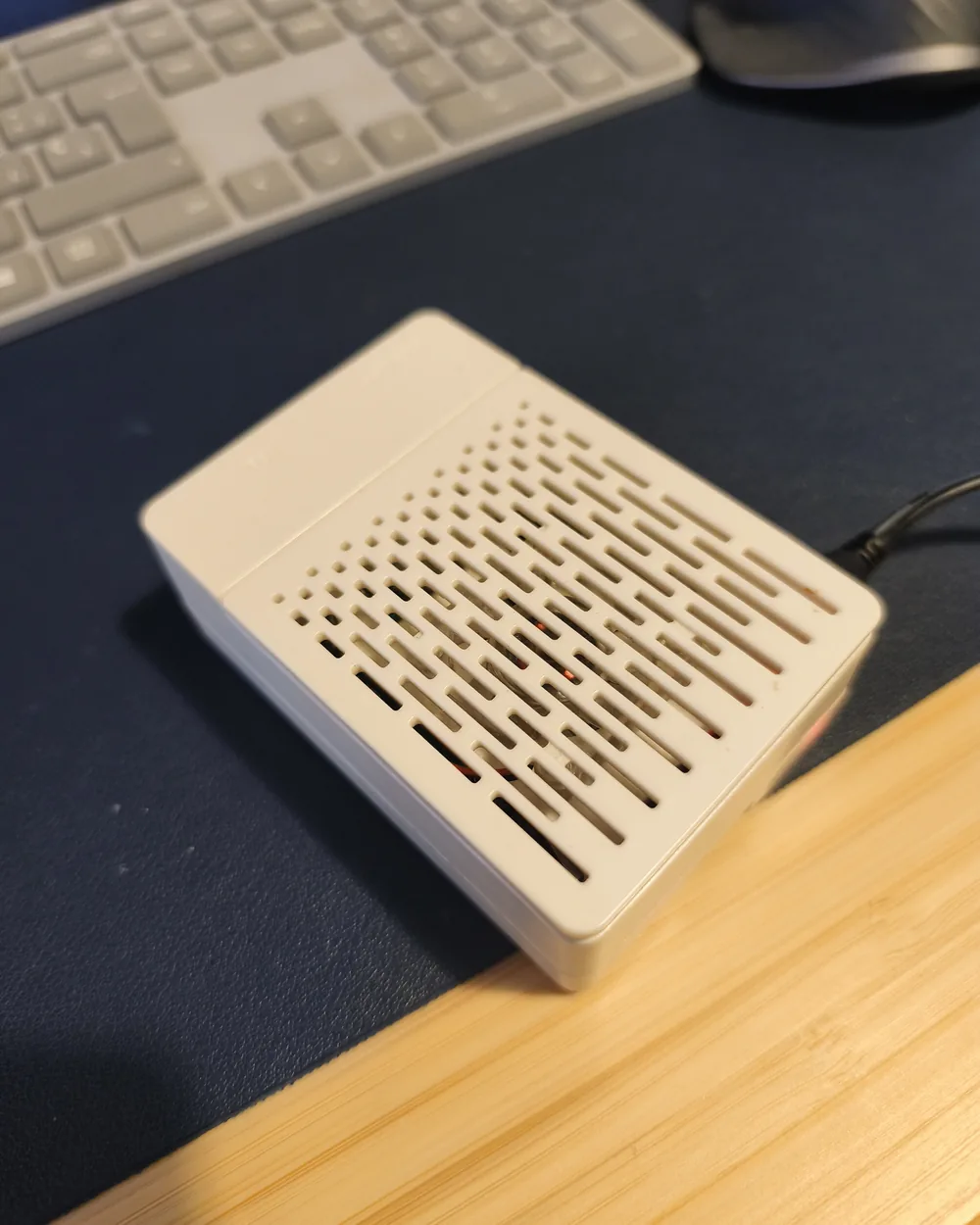 A white-cased Raspberry Pi 3 B+ on a desk next to a keyboard